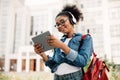 Happy Black Female Student Using Tablet Computer Wearing Headphones Outside Royalty Free Stock Photo