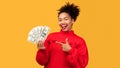 Happy black girl holding money at studio