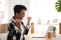 Excited woman feels happy sitting at the desk indoors Royalty Free Stock Photo