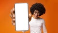 Happy black guy demonstrating smartphone with big blank white screen, showing space for your ad, app or website design Royalty Free Stock Photo