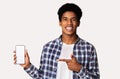 Happy black guy holding smartphone with blank screen
