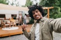 Happy black guy taking selfie near RV, smiling at camera, resting with his multiracial friends outdoors, copy space Royalty Free Stock Photo