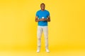 Happy Black Guy Using Cellphone Texting Standing Over Yellow Background Royalty Free Stock Photo