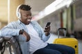 Happy Black Guy Using Smartphone While Relaxing oOn Bench At Railway Station Royalty Free Stock Photo