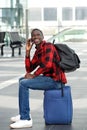 Happy black guy waiting at train station and using cellphone Royalty Free Stock Photo