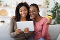 Happy black ladies shopping online, using digital tablet at home Royalty Free Stock Photo