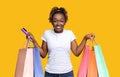 Happy black lady with shopping bags and credit card Royalty Free Stock Photo