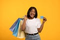 Happy black lady with shopping bags and credit card Royalty Free Stock Photo