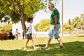 Happy black little boy and man with beard play ball football in park, enjoy sport competition Royalty Free Stock Photo