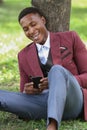 A happy male black worker looking at his phone