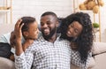 Happy black man laughing with wife and daughter at home Royalty Free Stock Photo