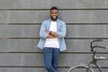 Happy Black Man Leaning On Wall And Standing Near His Bicycle Royalty Free Stock Photo