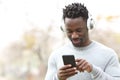 Happy black man listening music on phone with headphones Royalty Free Stock Photo