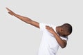 Happy black man making dab gesture on blank studio background