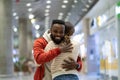 Happy black man meeting girlfriend in airport after long time, couple hugging at arrival gate Royalty Free Stock Photo