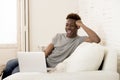 Happy black man sitting at home sofa couch working or enjoying internet movie in laptop Royalty Free Stock Photo