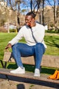 Happy black man talking on smart phone sitting in a park on a sunny day. Royalty Free Stock Photo