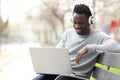 Happy black man watching media on laptop with headphones Royalty Free Stock Photo