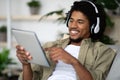 Happy Black Man In Wireless Headphones Using Digital Tablet At Home Royalty Free Stock Photo