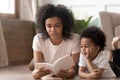 Happy black mom reading fairy tales to cute son. Royalty Free Stock Photo