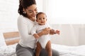 Happy Black Mother Helping Her Infant Baby Stand Up Indoor