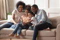 Happy black parents and children using digital tablet on sofa Royalty Free Stock Photo