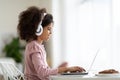 Happy black preteen girl using laptop, doing homework Royalty Free Stock Photo