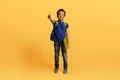 Happy black schoolboy with backpack and exercisebook showing thumb up Royalty Free Stock Photo