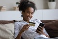 Happy Black shopping girl using banking app Royalty Free Stock Photo