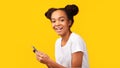 Happy black teenager using cell phone looking at camera Royalty Free Stock Photo