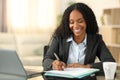 Happy black tele worker filling form at home