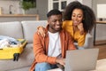 Happy black travelers couple planning vacation travel with laptop indoors Royalty Free Stock Photo