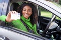 Happy black woman driving her new car holding car license Royalty Free Stock Photo