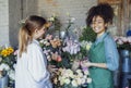 Happy black woman entrepreneur standing in plant store selling fresh flowers to client Royalty Free Stock Photo