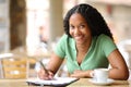 Happy black woman filling form in a bar looking at you Royalty Free Stock Photo