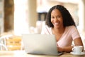 Happy black woman with laptop posing in a bar Royalty Free Stock Photo
