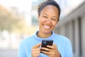 Happy black woman laughing holding phone looking at you Royalty Free Stock Photo