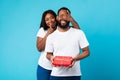 Happy black woman making surprise for her boyfriend giving box Royalty Free Stock Photo