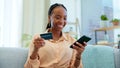 Happy black woman, phone and credit card on sofa for payment, online shopping or fintech at home. African female person Royalty Free Stock Photo