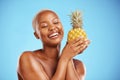 Happy black woman, pineapple and diet for natural nutrition or health against a blue studio background. African female