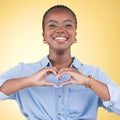 Happy black woman, portrait and heart hands for love, care or support against a yellow studio background. Face of Royalty Free Stock Photo