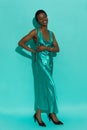 Happy beautiful black woman in a turquoise satin long dress