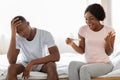 Happy black woman with pregnancy test and her unhappy boyfriend Royalty Free Stock Photo