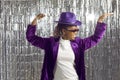 Happy Black woman in a purple hat and disco glasses dancing and having fun at a party Royalty Free Stock Photo