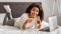 Happy black woman showing debit credit card, using laptop Royalty Free Stock Photo