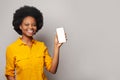 Happy black woman showing empty blank screen display smart phone against white studio wall background Royalty Free Stock Photo