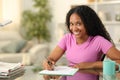 Happy black woman signing contract or filling form looks at you Royalty Free Stock Photo