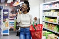 Happy black woman, supermarket and shopping with phone call, choice or discount in funny chat, customer experience Royalty Free Stock Photo