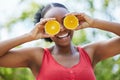 Happy black woman, vitamin C and orange on eyes for natural nutrition or citrus diet in nature outdoors. Portrait of Royalty Free Stock Photo