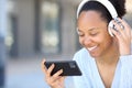 Happy black woman watching videos in the street Royalty Free Stock Photo